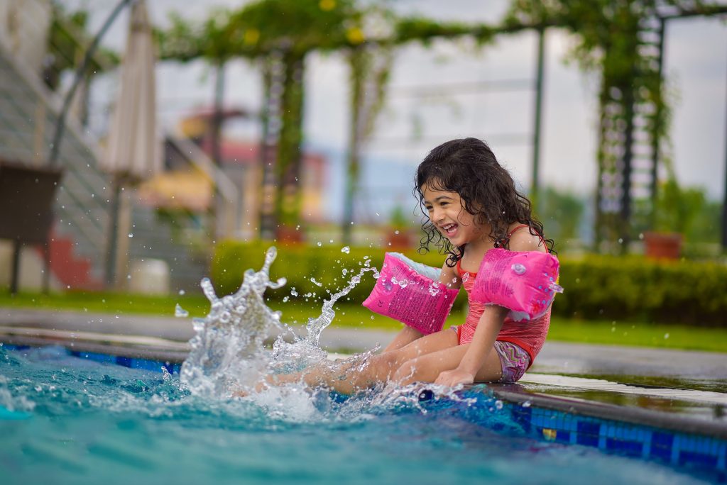 little girl splashing with puddle jumper on
