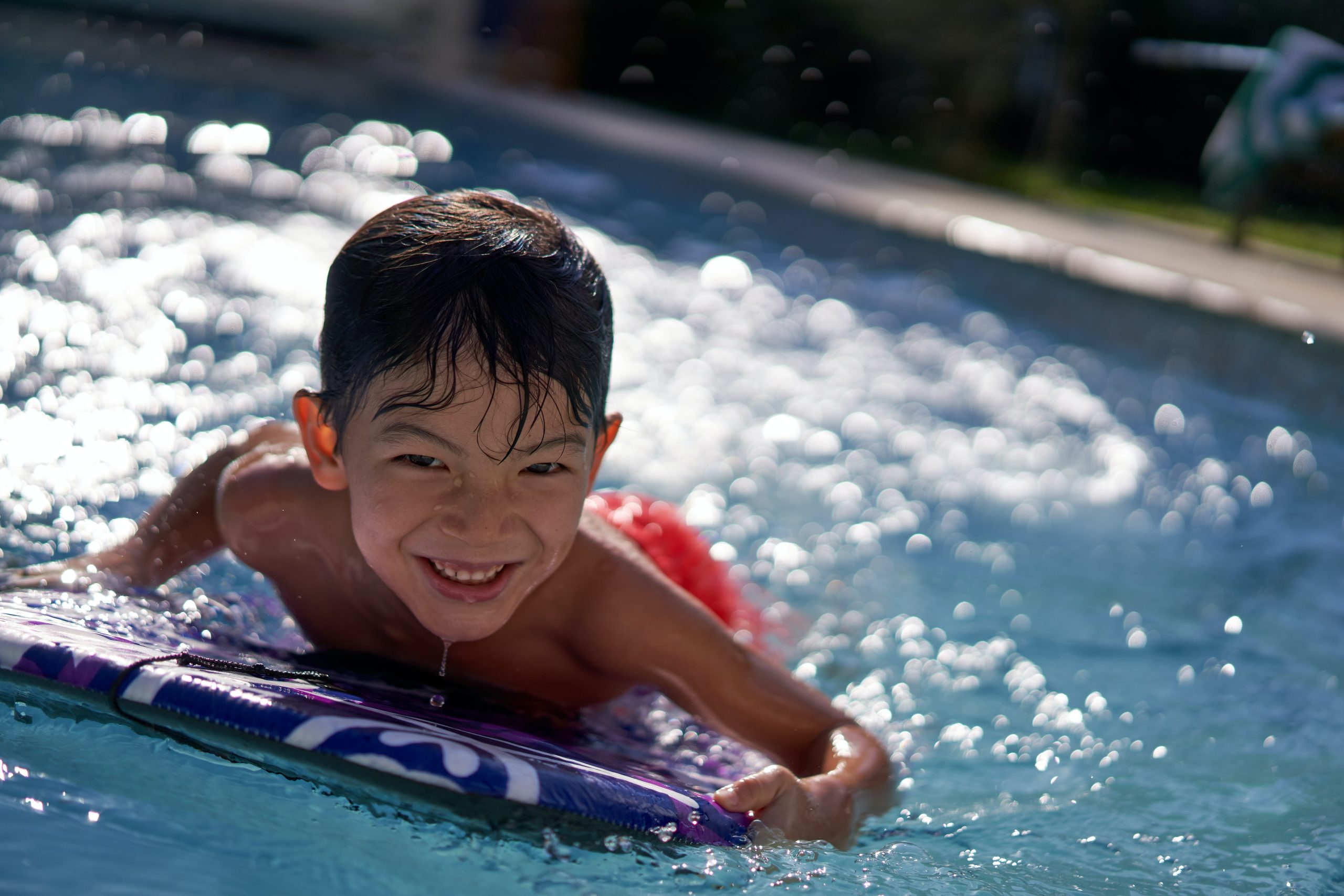little boy smiling on kickboard